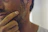 Close-up of a confident man touching his smooth jawline after laser session.