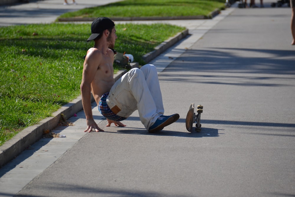 man using skateboard beside green grasses during daytime