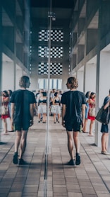 man walking beside mirror wall building