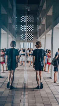 man walking beside mirror wall building
