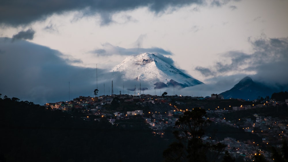 Pueblo con luces lejos de campo de montaña con nieve