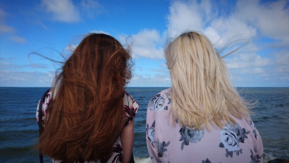 Fotografie von zwei Frauen, die tagsüber den Horizont sehen