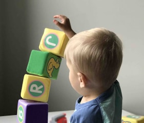 boy playing cube on white wooden table