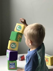 boy playing cube on white wooden table