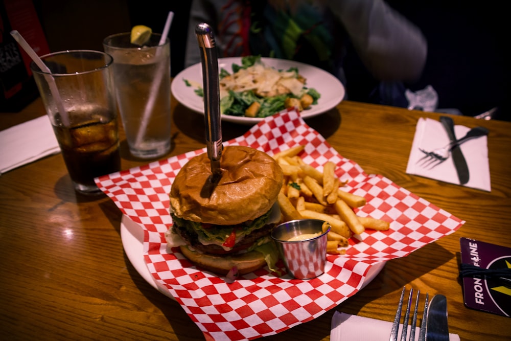 ハンバーガーとフライド ポテトを皿に盛る