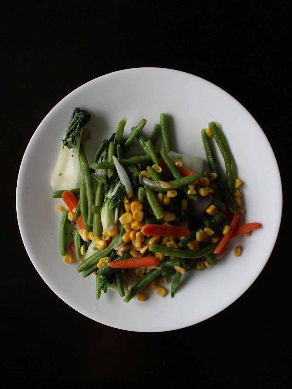 corns and sliced carrots on white plate