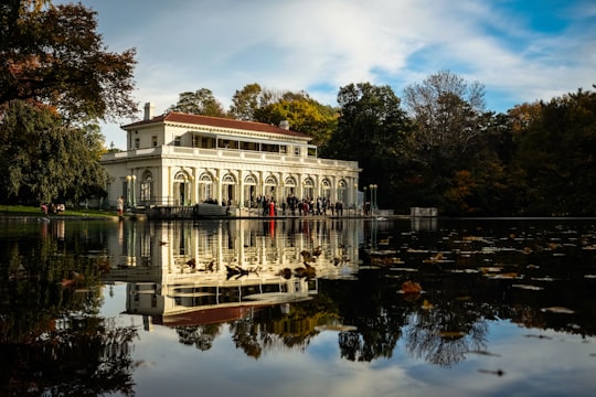 people near beige concrete building during daytime in Boathouse on the Lullwater of the Lake in Prospect Park United States