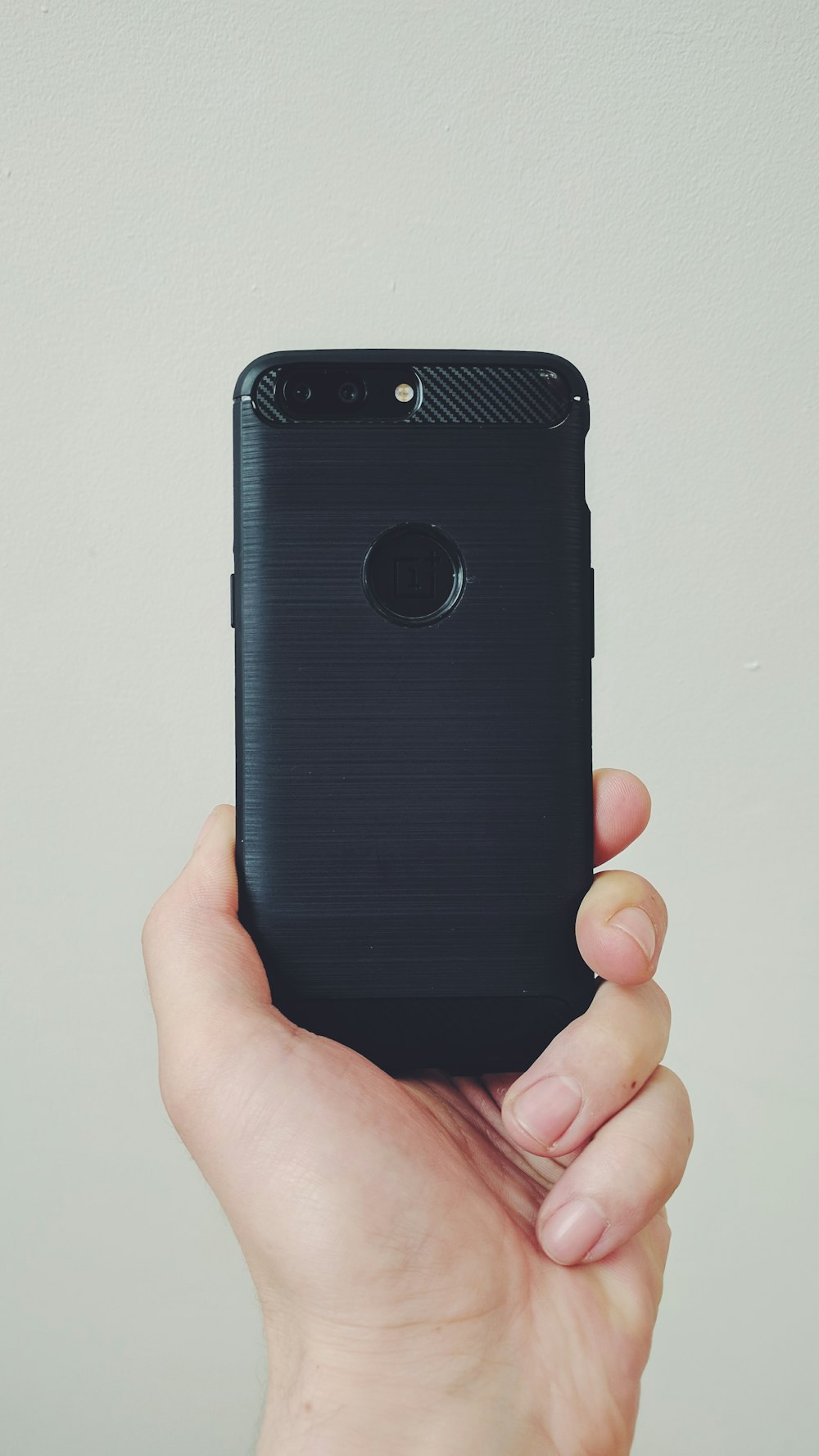 A person holding black phone.