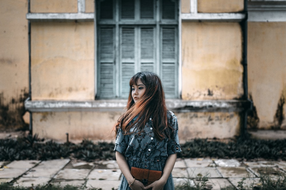 woman in gray dress holding brown bag