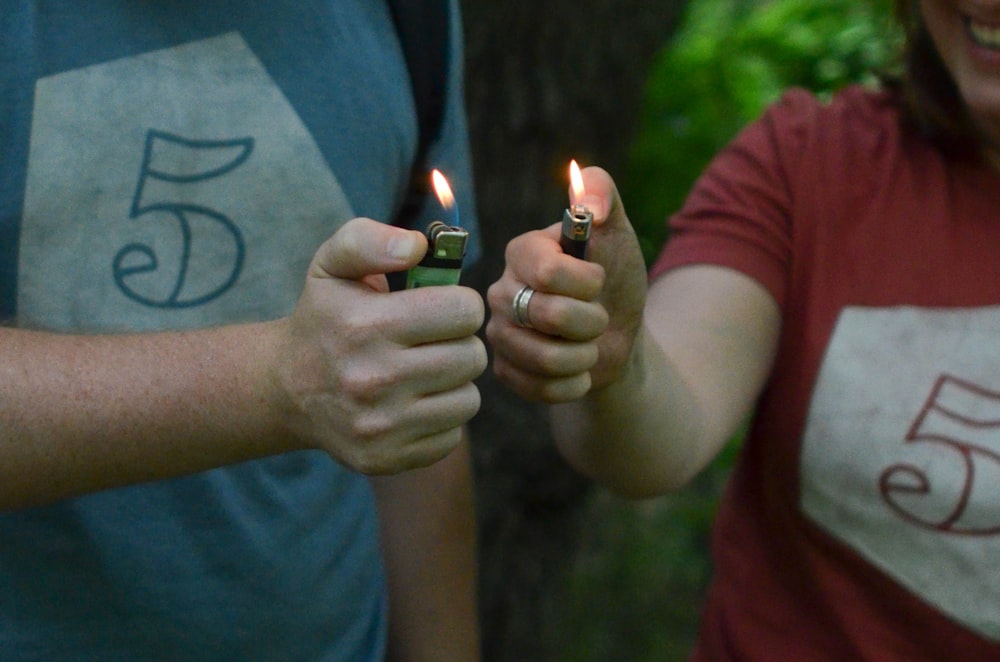 man and woman lit the two lighters they are holding