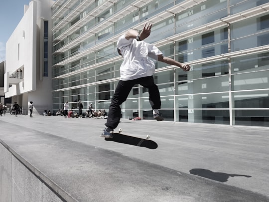 man skateboarding beside building during daytime in Barcelona Museum of Contemporary Art Spain