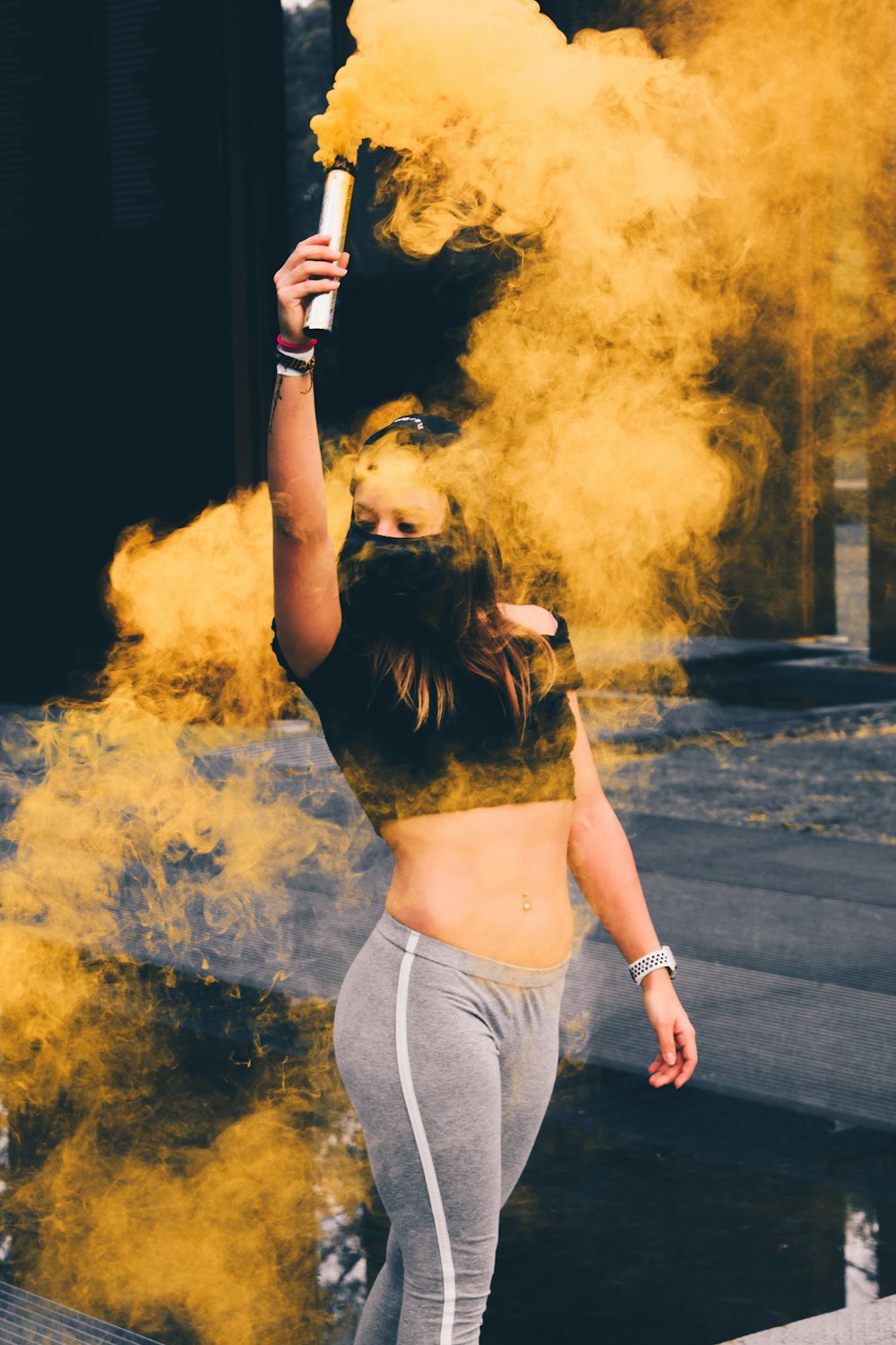 macro photography of woman wearing mask while raising smoke bomb