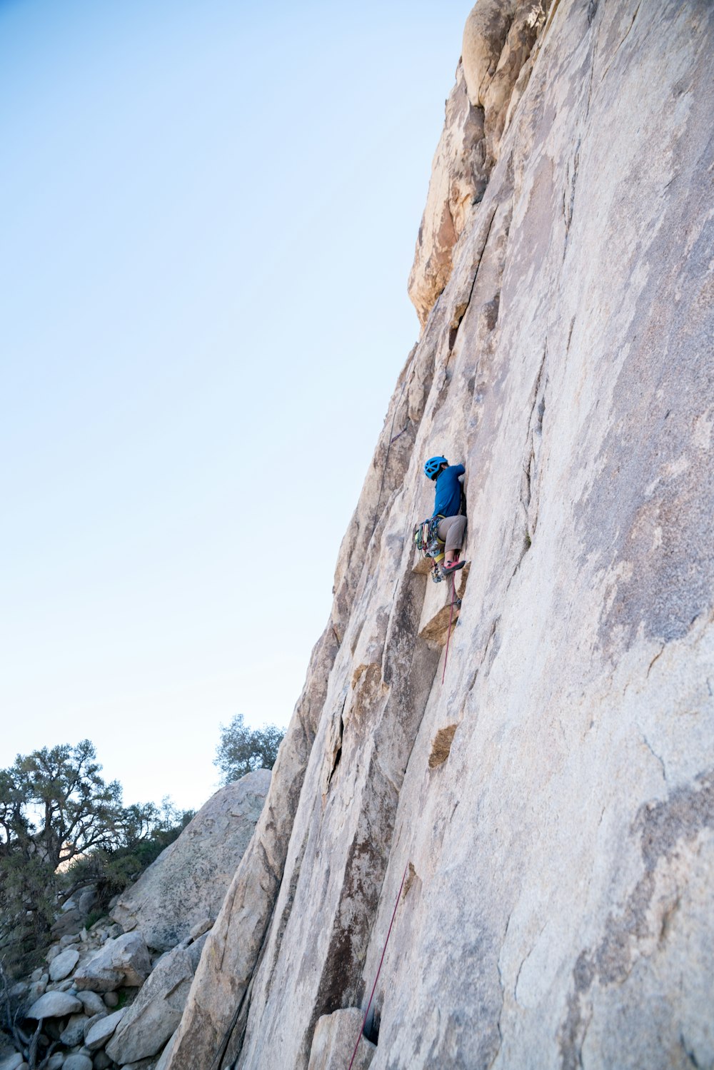 person rock climbing on rocky mountain wall during daytime