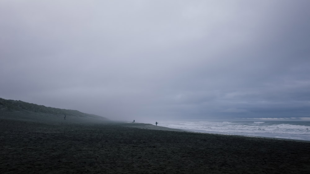 silueta de personas en la orilla del mar durante el día