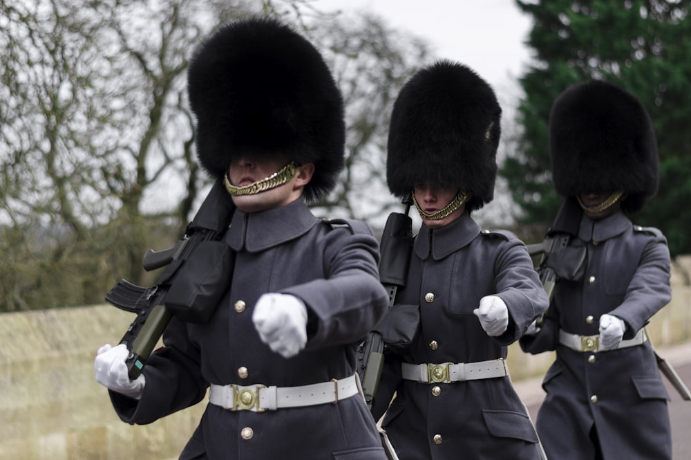 três guardas da rainha carregando submetralhadoras