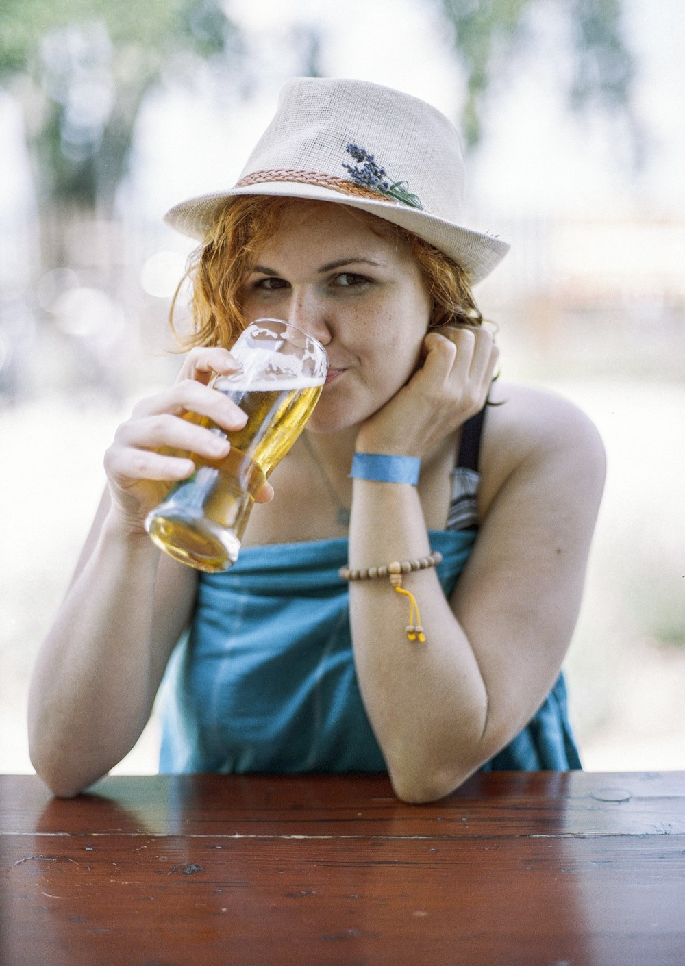 mulher bebendo copo de cerveja durante o dia