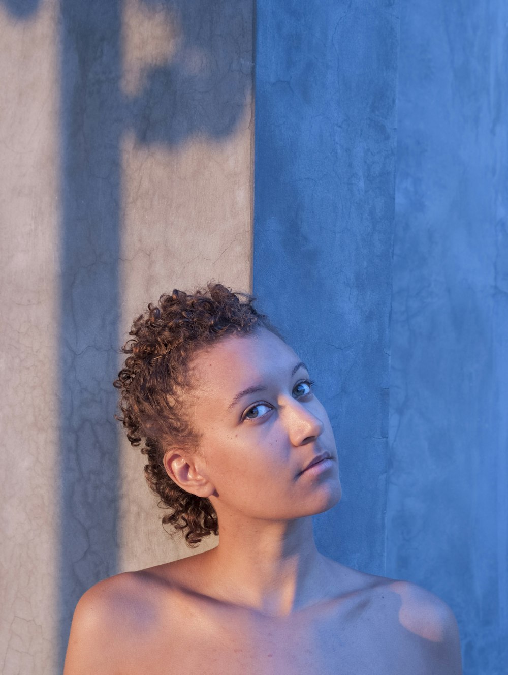 woman next to gray wall during daytime