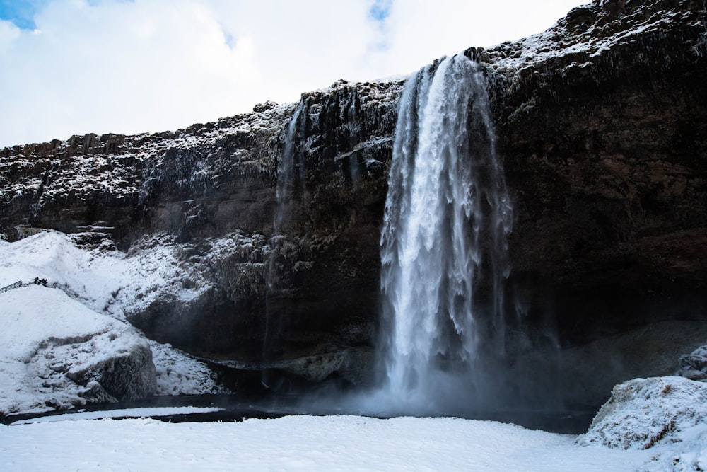 low angle photography of snow-covered waterfalls