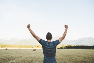 man reaching hands up high taken at daytime