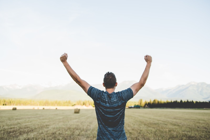 Man reaching hands up high, representing reclaimed confidence