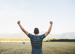 man reaching hands up high taken at daytime