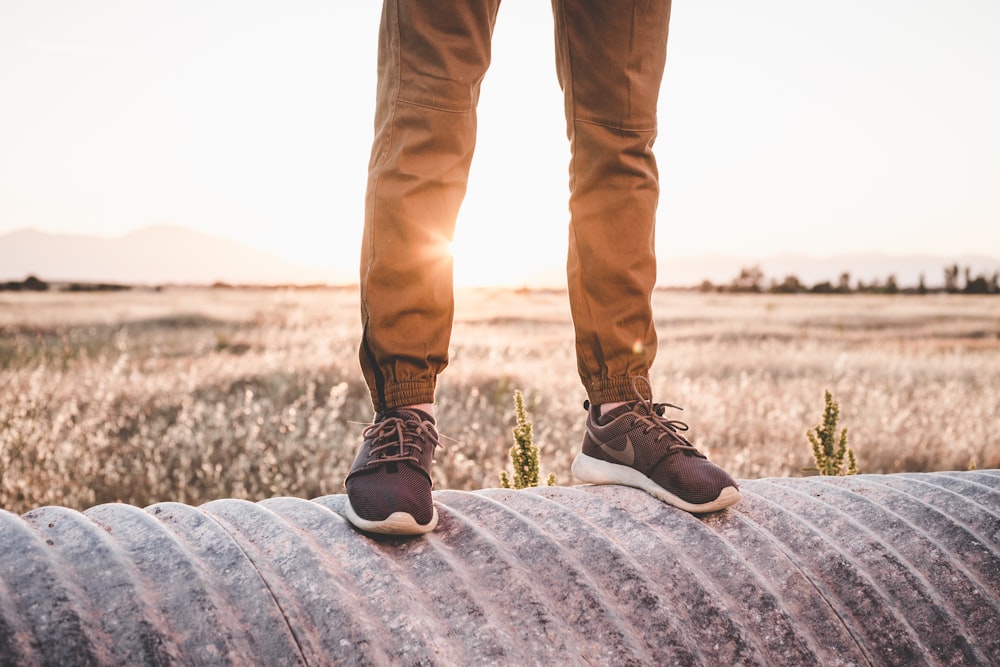photographie filtrée d’un homme portant des chaussures Nike debout à un tambour enfilé avec un paysage à l’arrière