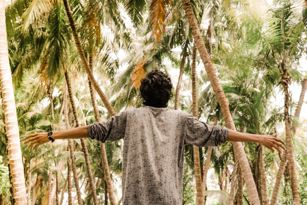 man in gray top near palm trees