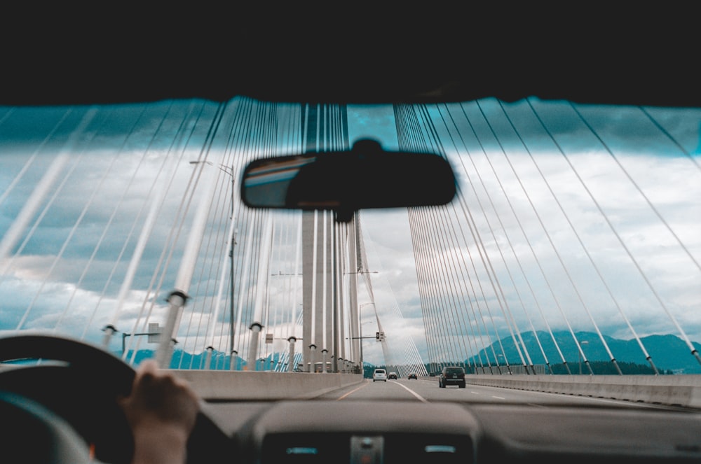 person inside car taking photo of bridge
