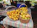 A basket overflowing with ripe, juicy mangoes on a rustic wooden table.
