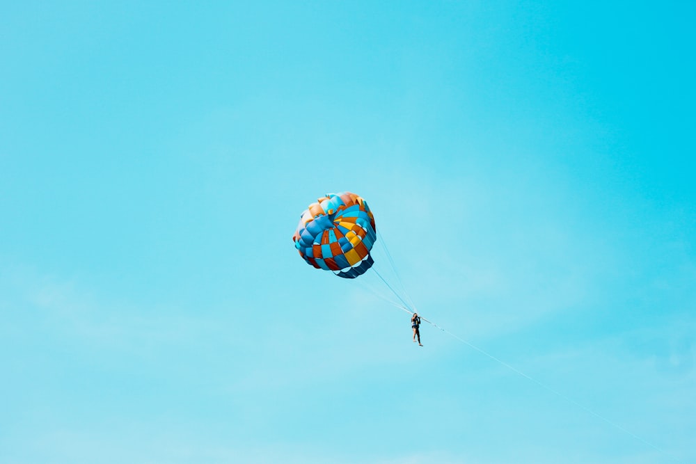 pessoa usando paraquedas no céu