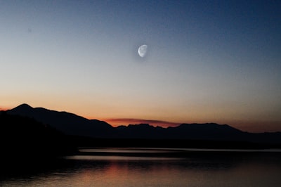 silhouette of mountains near body of water during golden hour kosovo zoom background