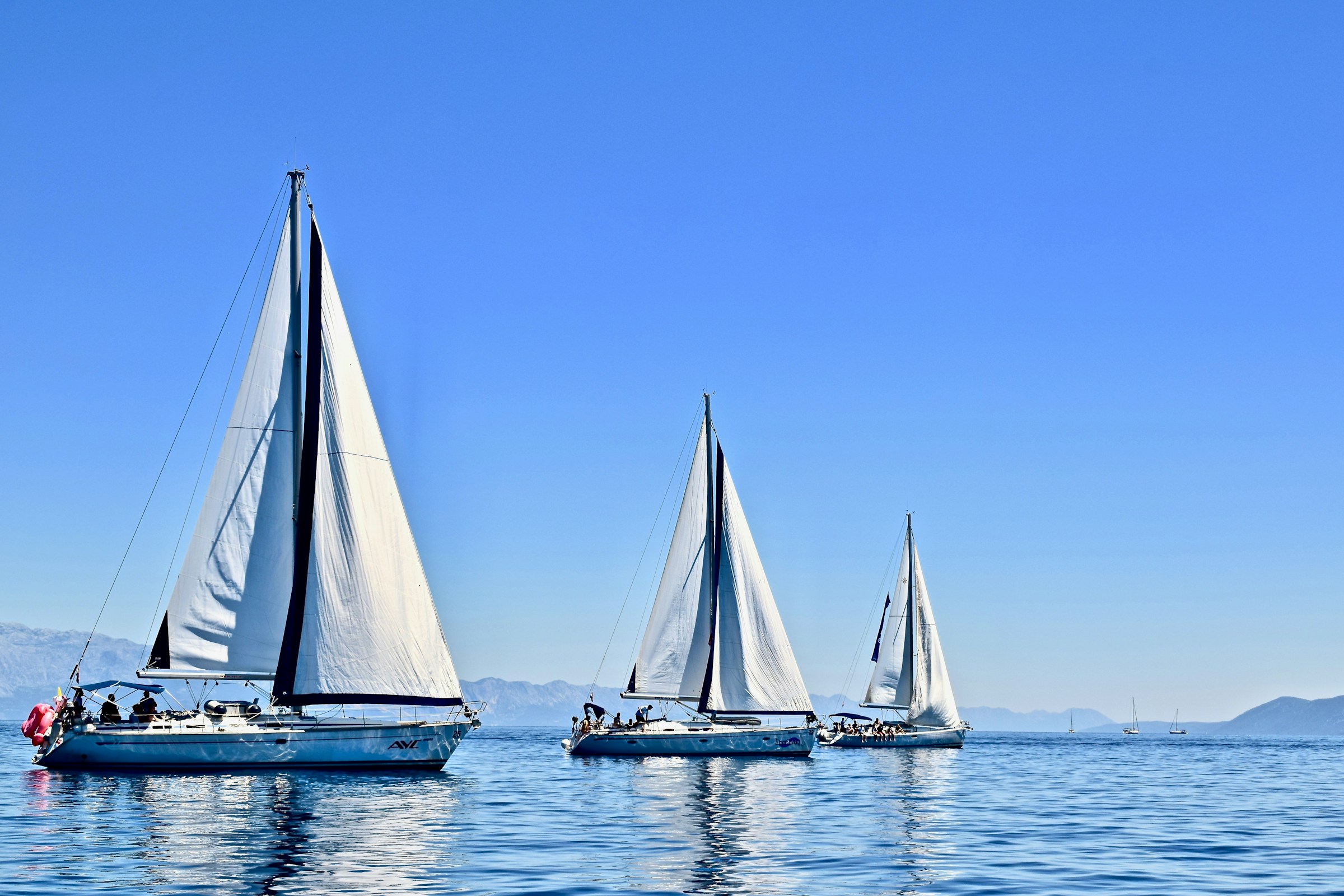 A sailing yacht crossing open water in low evening light