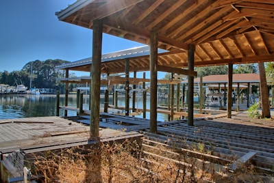A freshly built wooden dock extending over calm water with a boat lift installed.