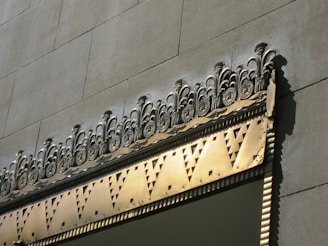 Decorative metal elements with detailed laser-cut designs displayed against a modern building facade.