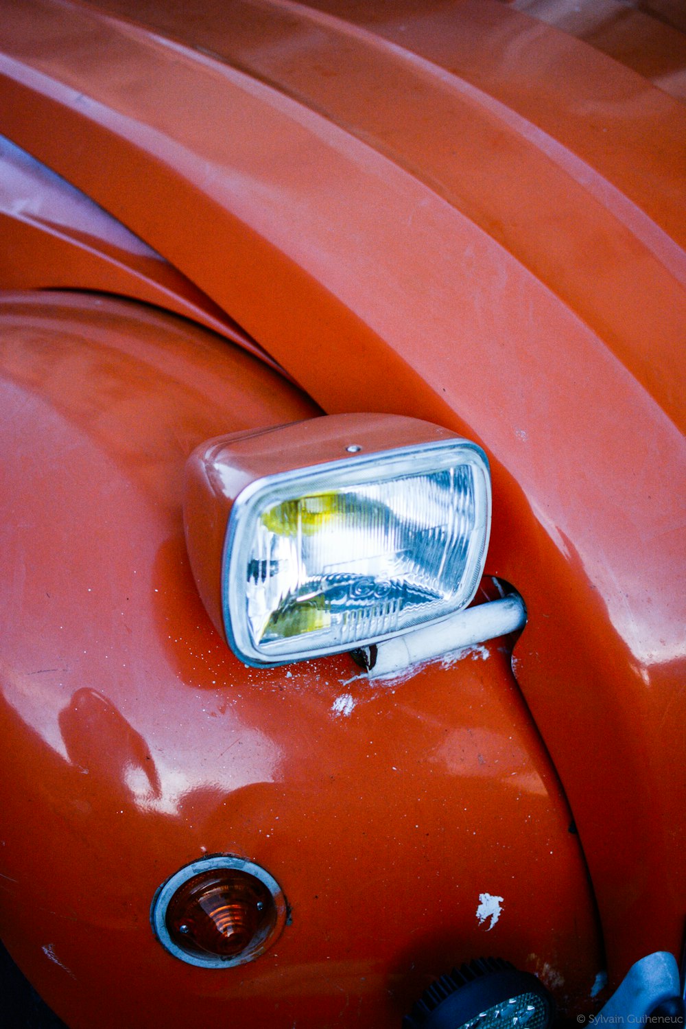 close view of red vehicle with headlight