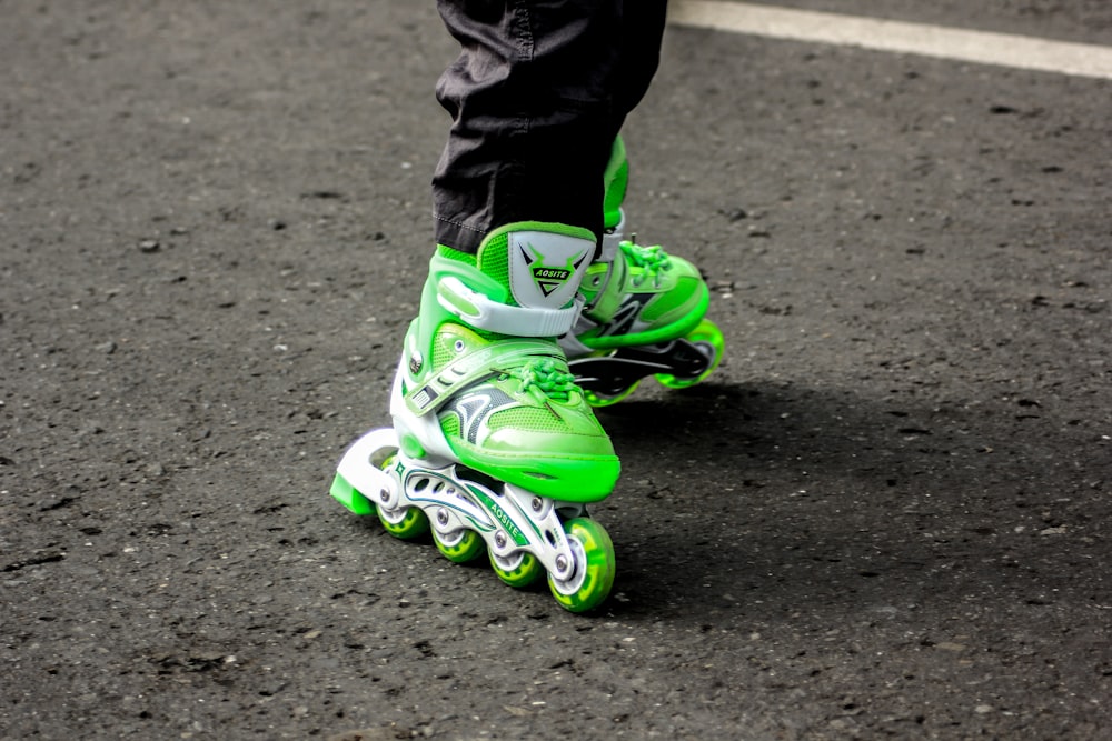 person wearing pair of green inline skates