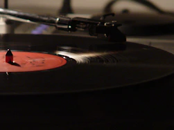 A close-up of a vinyl record spinning on a turntable in warm lighting