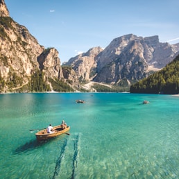 three brown wooden boat on blue lake water taken at daytime