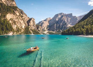 three brown wooden boat on blue lake water taken at daytime