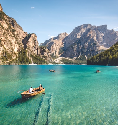 three brown wooden boat on blue lake water taken at daytime