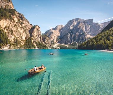 three brown wooden boat on blue lake water taken at daytime