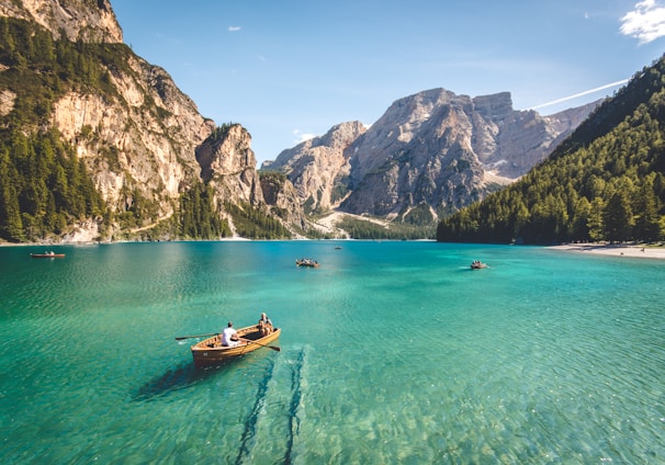 three brown wooden boat on blue lake water taken at daytime