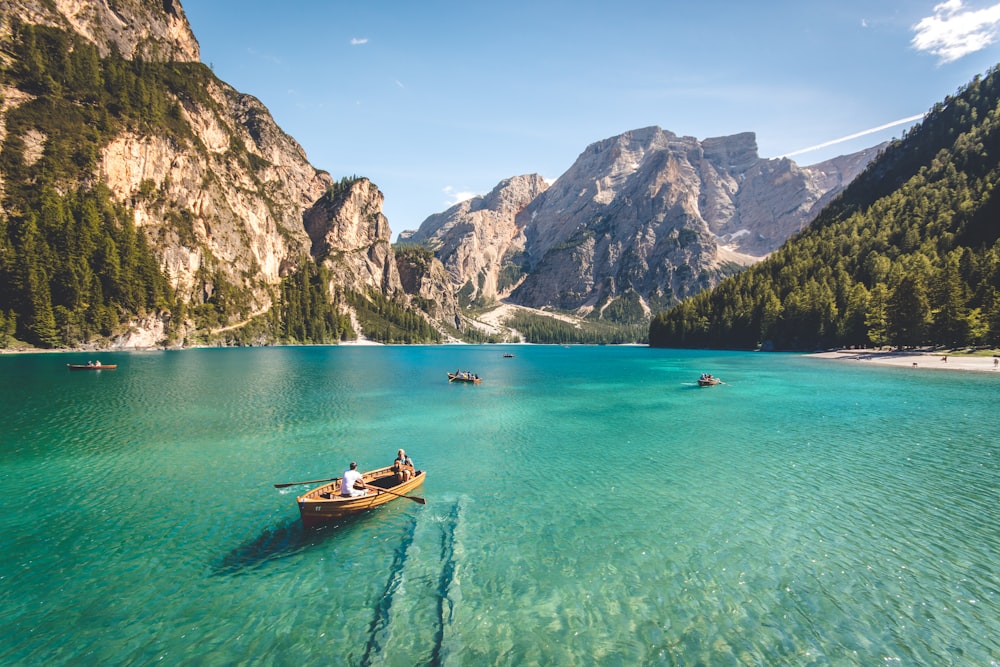 昼間に撮影した青い湖の水に 3 つの茶色の木製ボート