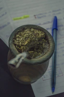Classic Uruguayan mate cup made of calabash with a metal straw, surrounded by yerba mate.