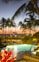 A peaceful resort garden with lounge chairs and tropical greenery under soft sunlight.