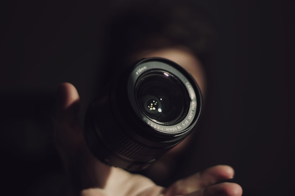 person holding camera lens