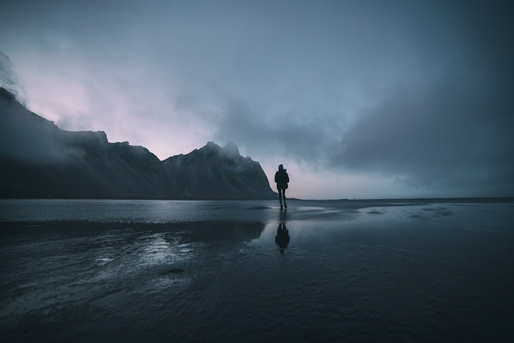 man standing on seashore during daytime