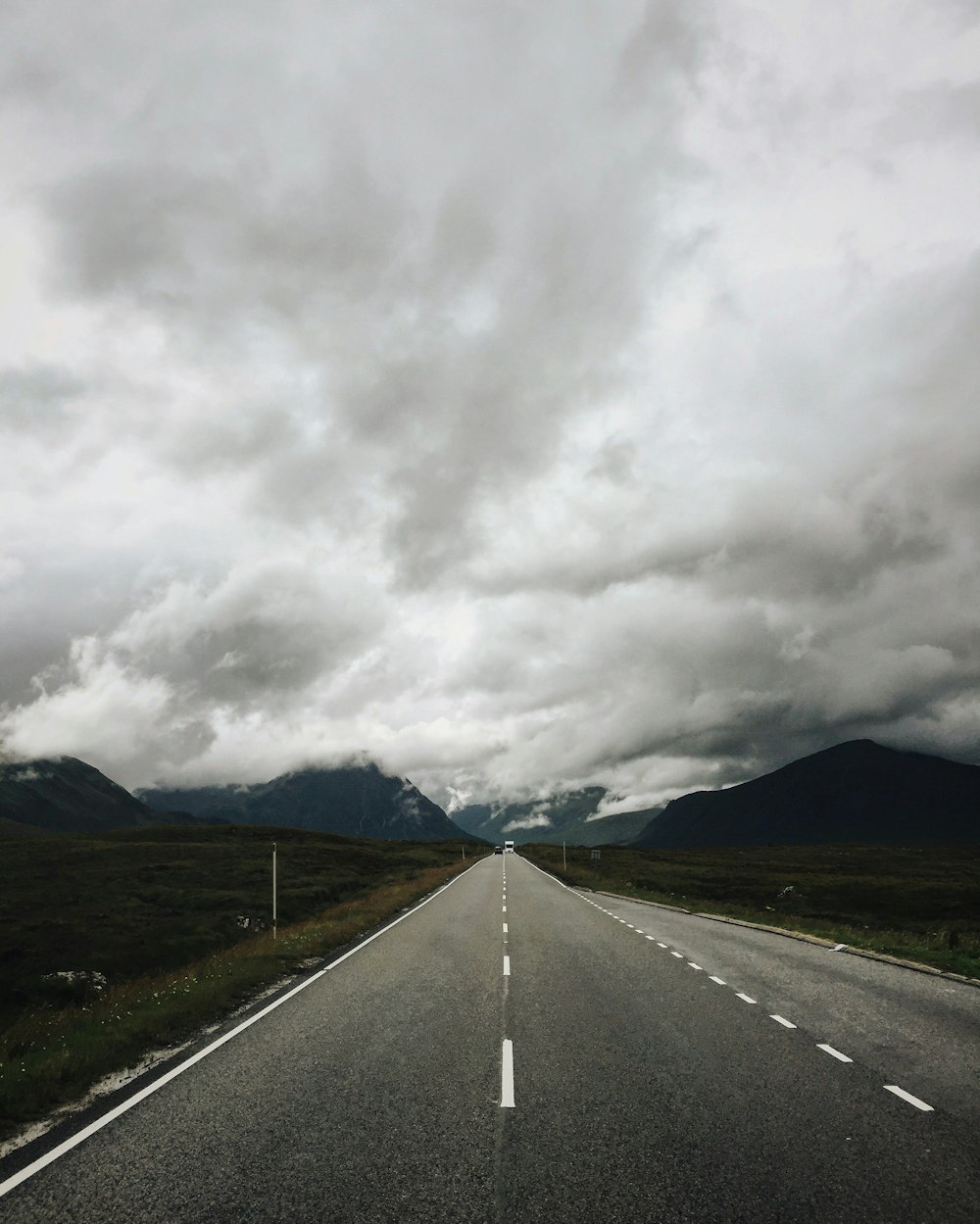 empty asphalt road under nimbus clouds