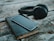 space gray iPhone 6 on book near black wireless headphones