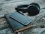 space gray iPhone 6 on book near black wireless headphones